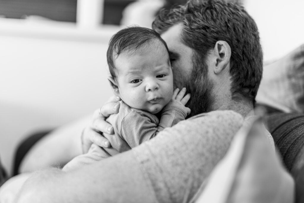 close up father holding baby grayscale